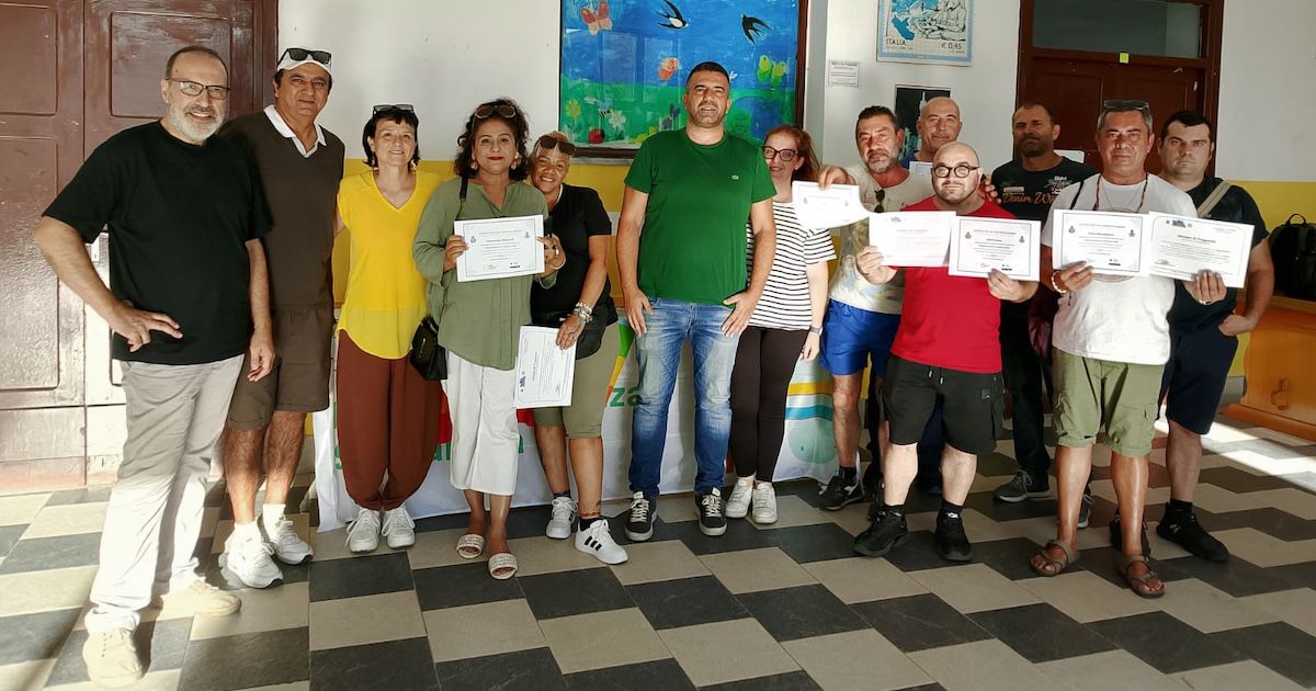 Il gruppo di volontari, operatrici e operatori dopo la consegna degli attestati. Al centro e sulla destra i partecipanti mostrano gli attestati.
